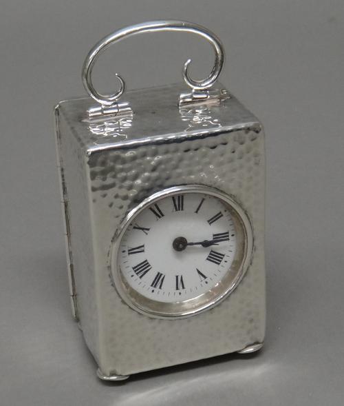 A silver rectangular cased carriage clock timepiece, the backplate of the movement detailed French Movement, the case exterior with martele decoration
