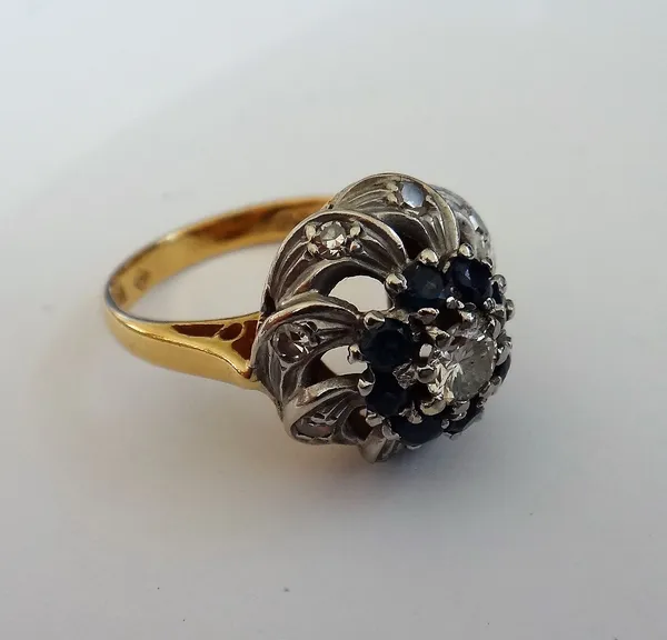 An 18ct gold, diamond and sapphire cluster ring, claw set with the principal circular cut diamond at the centre, in a surround of eight circular cut s