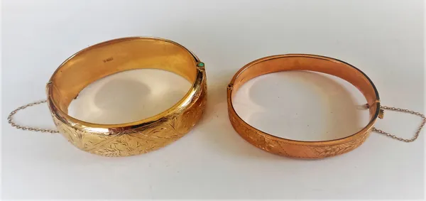 A 9ct gold loaded oval hinged bangle, the front with floral engraved decoration, Birmingham 1963 (the clasp broken) and another 9ct gold oval hinged b