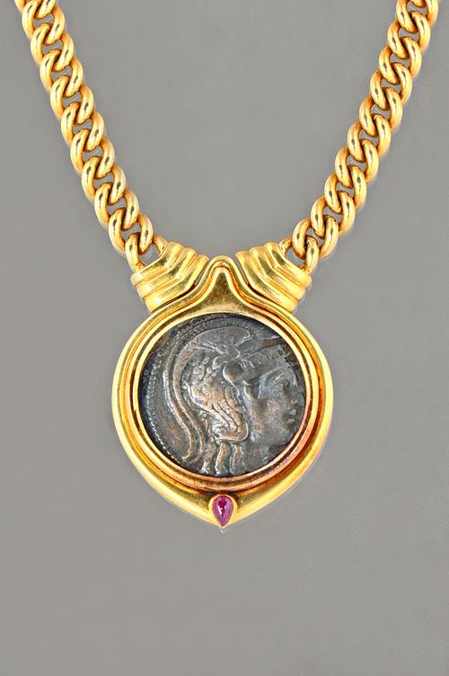 A Bvlgari gold collar necklace, the front mounted with a Greek coin above a pear shaped cabochon ruby, detailed to the back ATHENS 196-87 BC. TETRADRA
