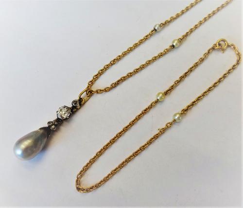 A gold backed and silver set diamond and cultured pearl pendant necklace, claw set with the principal cushion shaped diamond above three small cushion