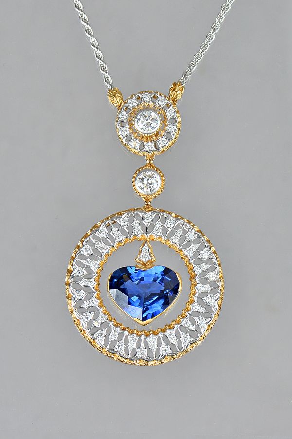 An Italian gold, diamond and sapphire set pendant necklace by Federico Buccellati, the principal circular drop centred by a heart shaped heat treated