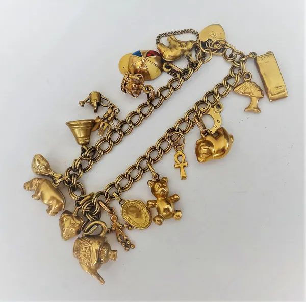 A 9ct gold twin curb link charm bracelet, with a heart shaped padlock clasp, fitted with seventeen mostly 9ct gold charms, gross weight 21.6 gms.