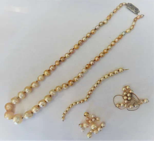 A single row necklace of graduated un-tested cultured pearls, of baroque form, fitted to a cabochon sapphire and rose diamond set rectangular two row