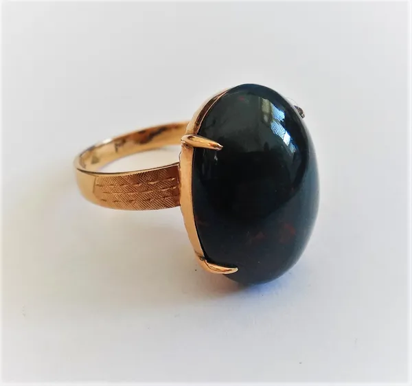 A gold ring, claw set with an oval cabochon bloodstone between decorated shoulders, detailed K 14, ring size L.