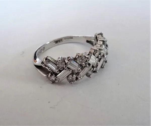 An 18ct white gold and diamond half hoop ring, mounted with rows of alternating baguette and circular cut diamonds, in a slanting design between split