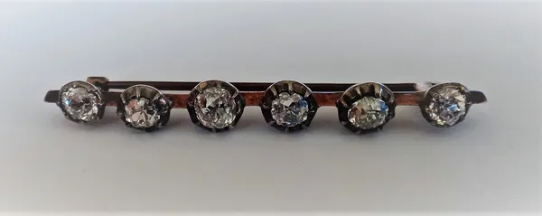 A diamond set six stone bar brooch, mounted with a row of cushion shaped diamonds, later fitted to a bar brooch.