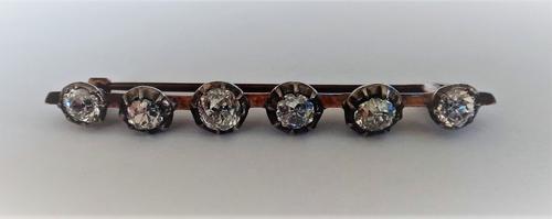 A diamond set six stone bar brooch, mounted with a row of cushion shaped diamonds, later fitted to a bar brooch.