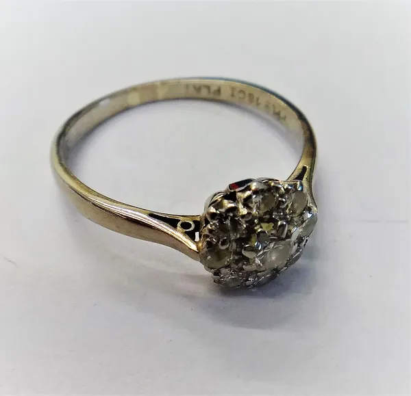 A white gold and platinum, diamond nine stone cluster ring, claw set with the principal circular cut diamond to the centre, in a surround of eight sma