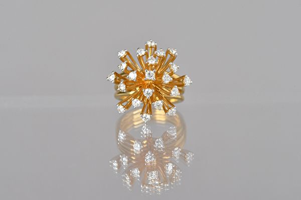 A gold and diamond set ring, in an abstract starburst shaped design, detailed 750 18 K, ring size N, gross weight 12.6 gms, with a case. Illustrated.