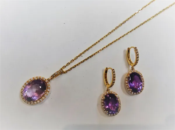 A gold, amethyst and diamond oval pendant, claw set with the oval cut amethyst at the centre, in an openwork surround, set with circular cut diamonds,