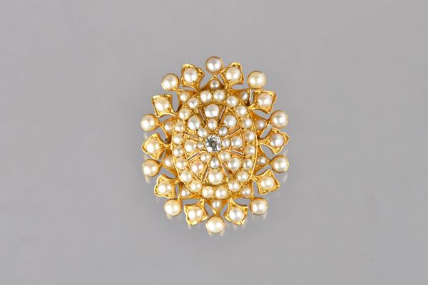 A Victorian gold, diamond and half pearl set oval brooch, mounted with the cushion shaped diamond at the centre and otherwise mounted with half pearls