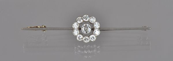 A diamond set cluster bar brooch, collet set with the principal cushion shaped diamond to the centre, in an openwork surround mounted with ten smaller