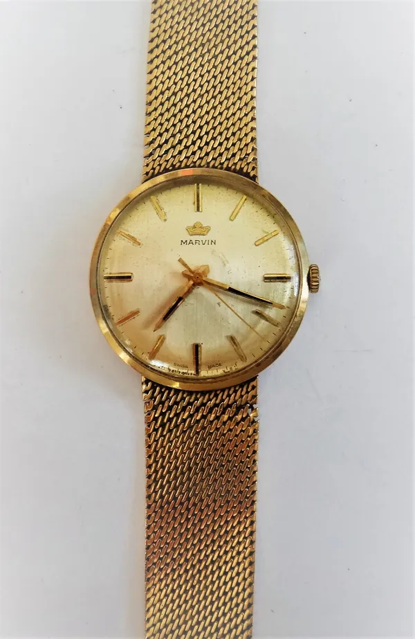 A Marvin 9ct gold circular cased gentleman's bracelet wristwatch, the signed circular dial, with gilt baton numerals and with centre seconds, on a tap