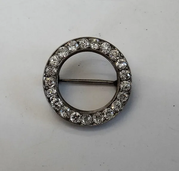 A diamond brooch, of circular openwork form, mounted with cushion shaped diamonds (probably the bezel from a lady's watch), diameter 2.3cm.