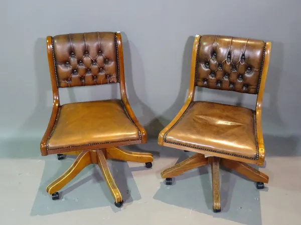 A pair of 20th century mahogany office chairs with faux green leather button back upholstery, (2).   BAY 1