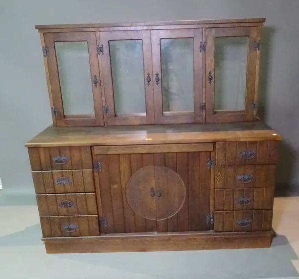 A 20th century oak display cabinet with four glass doors over cupboard base, flanked by four drawers, 142cm wide x 134cm high.  L8
