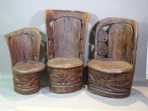 A 20th century African carved hardwood dining table 135cm wide, and six matching chairs with slab seats and leather cushions, (7).   BAY 1