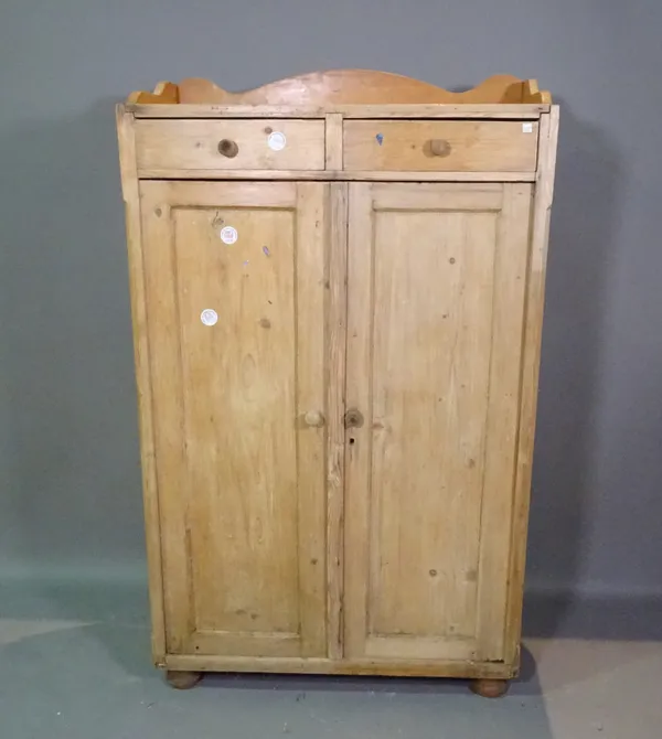 An early 20th century pine side cabinet with galleried top over two drawers and cupboard base, on bun feet, 92cm wide x 152cm high.   J10