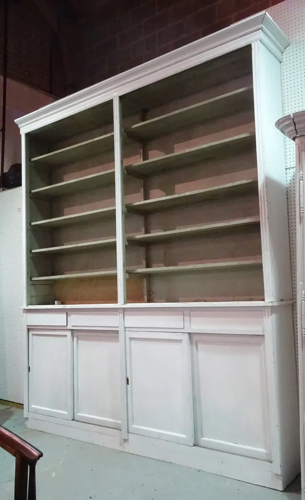An early 20th century white painted shopkeeper's display dresser with five tier top and sliding doors to base, 258cm long x 300cm high.   C10