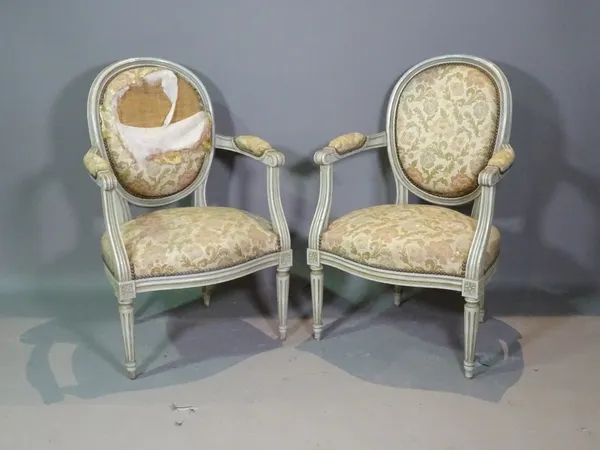 A pair of Louis XVI style grey panted open armchairs on fluted tapering supports, (2).   BAY 3