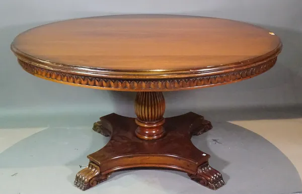 A Regency style mahogany circular dining table with reeded column and paw feet, 150cm wide x 83cm high.   F3