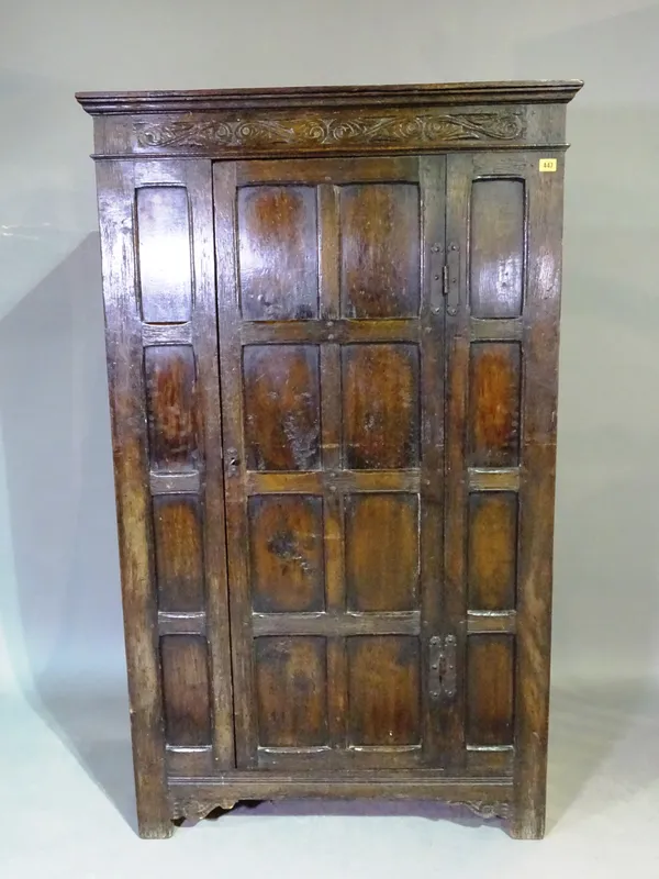 A 17th century style oak wardrobe with panelled door and bracket feet. 92cm wide, 160cm tall.  L10