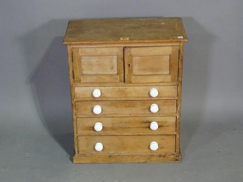 An early 20th century pine table top miniature chest with pair of doors over four graduated drawers, 47cm wide x 56cm high.  BAY 3