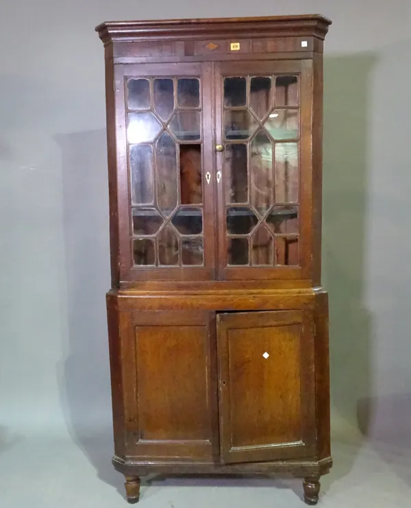 A George III oak floor standing corner display cabinet with astragal glass doors on turned supports, 88cm wide x 190cm high.   H10