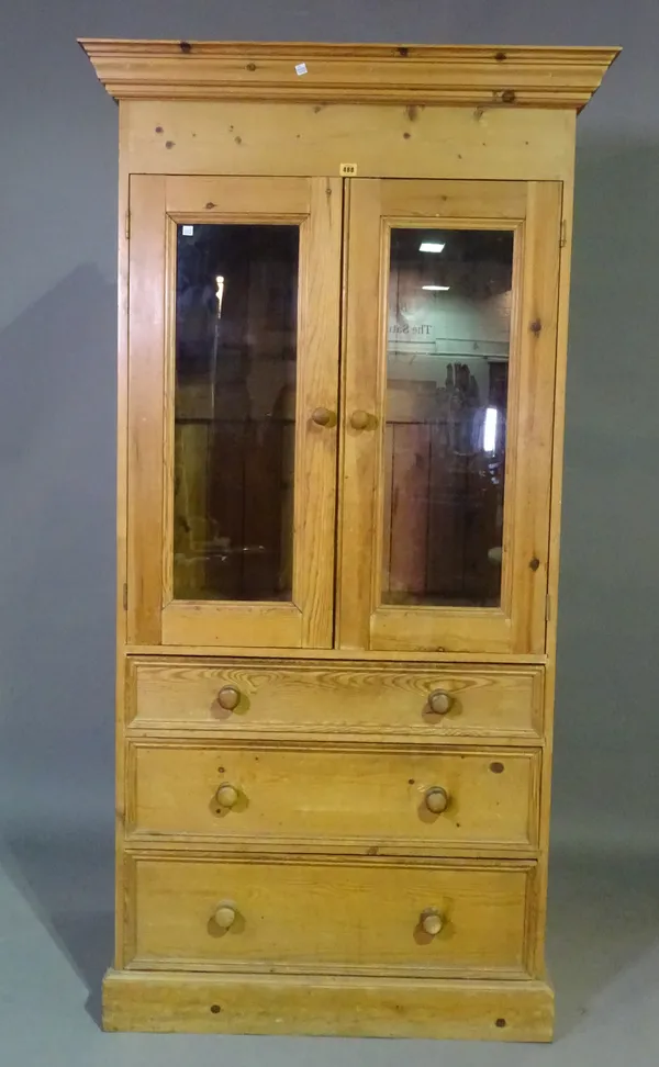 An early 20th century pine kitchen cabinet with pair of glazed doors over three graduated long drawers, 90cm wide x 186cm high.   M5