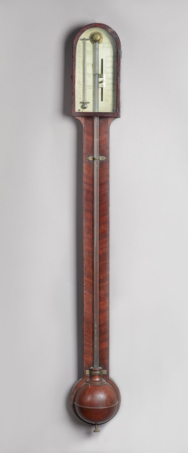 A George III mahogany stick barometer By Shuttleworth, London, circa 1800The arched pediment above a glazed door with silvered dial and vernier, above