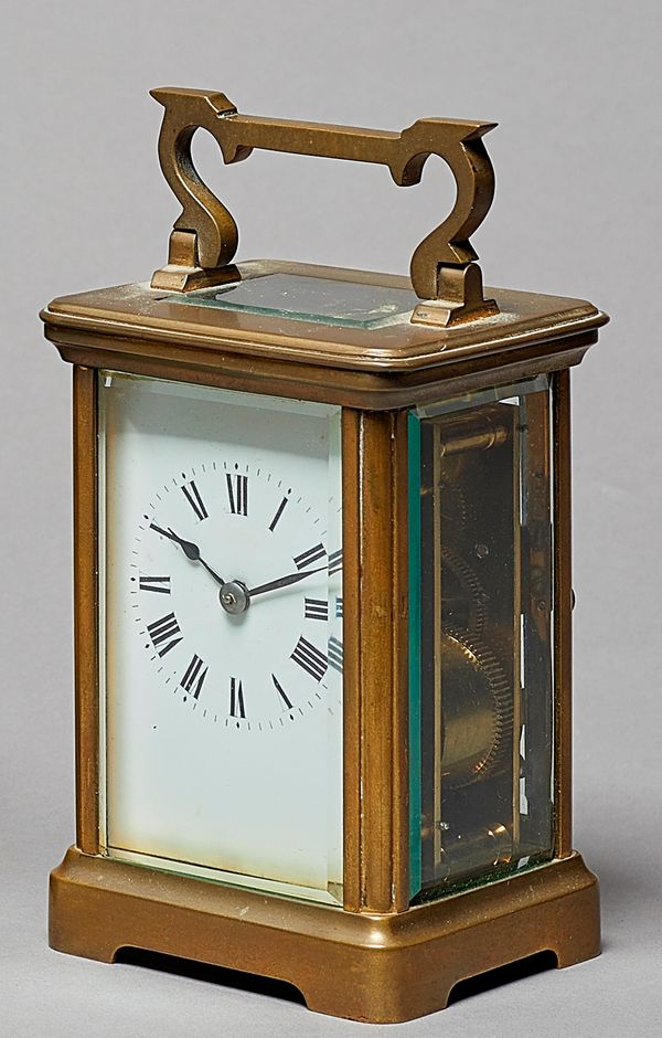 A French brass carriage clock Circa 1910In a plain case with bevelled glass panels, original platform lever escapement, with white enamel dial, striki