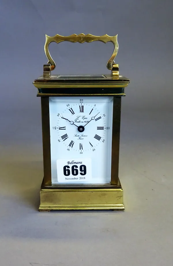 A French brass carriage timepiece By L'Epée, circa 1980The case with shaped handle above bevelled glazed panels, with signed white enamel dial and pla