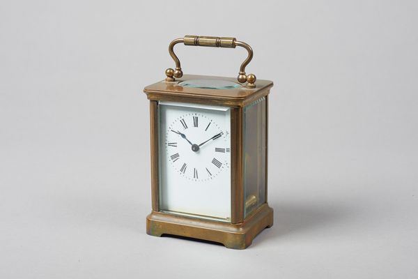 A French brass carriage timepieceLate 19th CenturyWith platform cylinder escapement, white enamel dial and plain case, together with its red morocco l