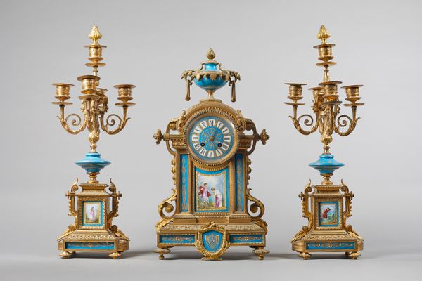 A Napoleon III ormolu and porcelain clock garnitureCirca 1865The clock surmounted by an urn above an arched pediment  on a stepped plinth with foliate