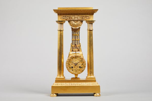 A French Empire ormolu portico clock By Humbert A Metz, circa 1820Of narrow proportion, the entablature cast with two pelicans, beside a woven basket