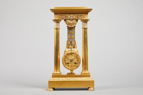 A French Empire ormolu portico clock By Humbert A Metz, circa 1820Of narrow proportion, the entablature cast with two pelicans, beside a woven basket