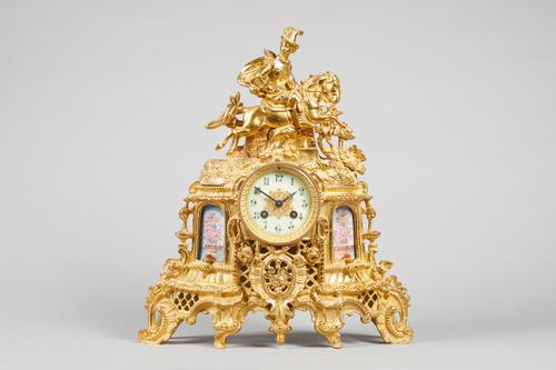 A French giltmetal and porcelain-mounted mantel clockCirca 1880The case modelled with an equestrian figure above the glazed cream enamel dial, flanked