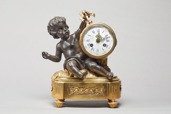 A French ormolu and patinated mantel clockIn the Louis XVI style, circa 1880Modelled with a seated cherub holding a drum, on an oval base with toupie