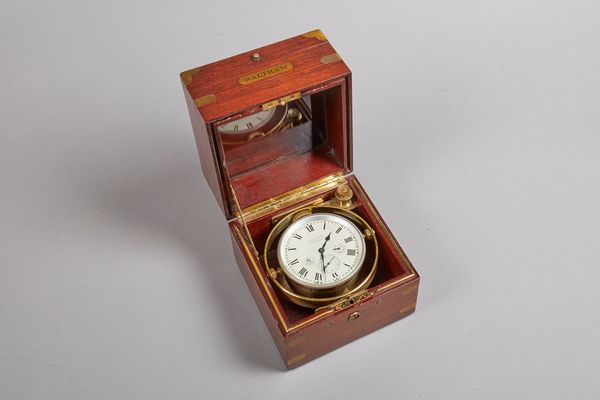 An American mahogany brass-bound deck watchBy The Waltham Watch Co. No 22131945The three-tier hinged case with glazed observation cover, with a shaped