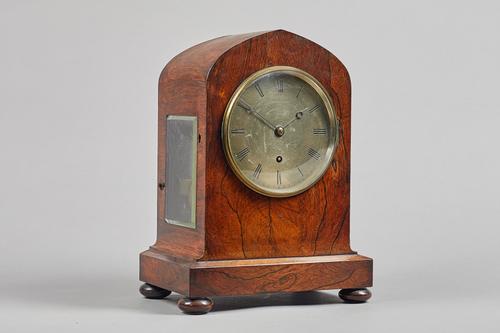 A Victorian lancet-shaped rosewood mantel timepieceBy De La Salle & Christie, London, circa 1840The case with a glass panel to each side, on a stepped