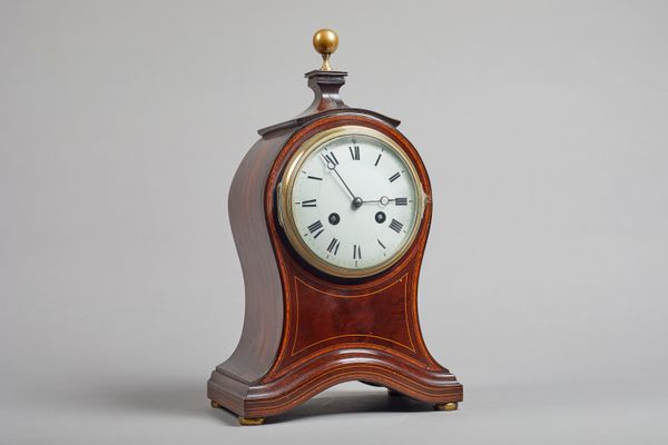 An Edwardian mahogany and boxwood line-inlaid balloon bracket clock The shaped case surmounted by a brass finial, above the convex glazed bezel, on br