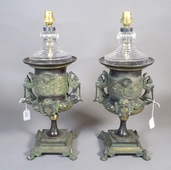 A pair of wooden bronze and glass table lamps, each of two handled urn form, Renaissance style with a green patina on a square base and four lion paw