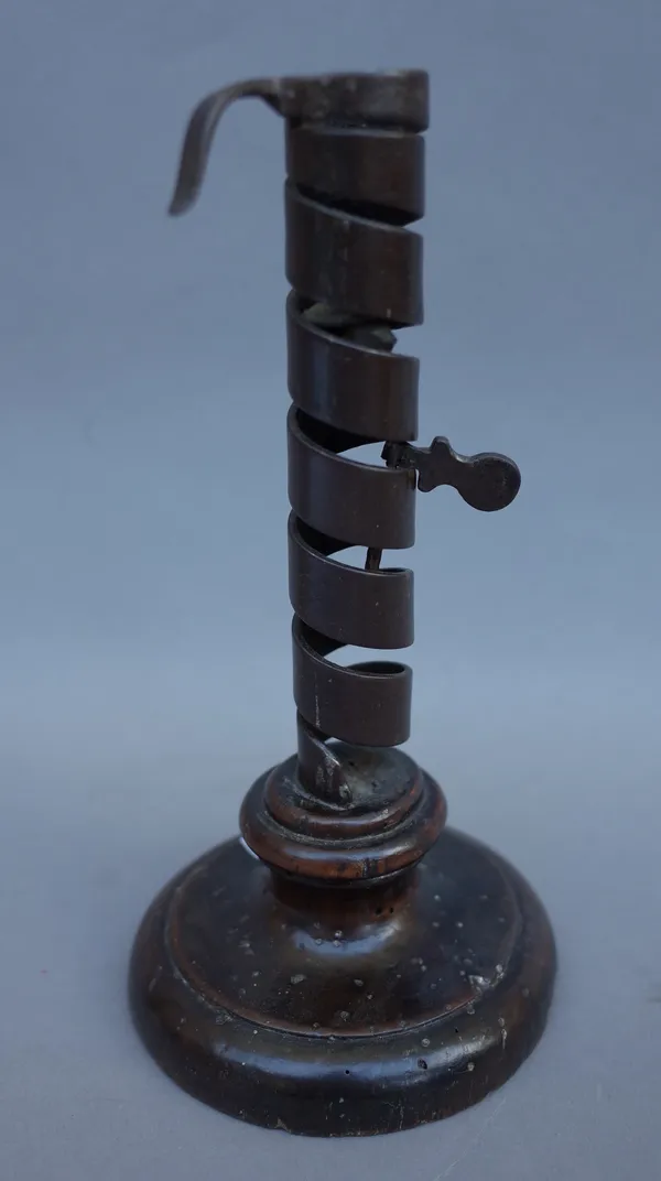 A sheet brass Hogscraper candlestick, circa 1790, 18cm high, an 18th century wrought iron and fruitwood adjustable candlestick of spiral twist form 20
