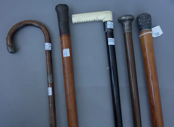 A 19th century Malacca walking stick with embossed Asian silver pommel (90cm), a hardwood cane with 20th century silver hallmarked pommel (91cm), a Vi