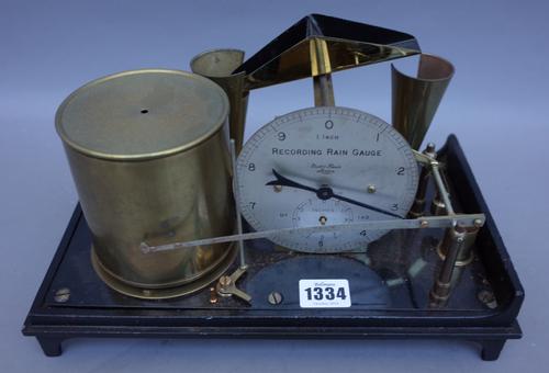 A Short & Mason rain recording gauge, early 20th century, brass and ebonised cast iron (30.5cm wide), a Victorian brass and steel wine bottle corker a