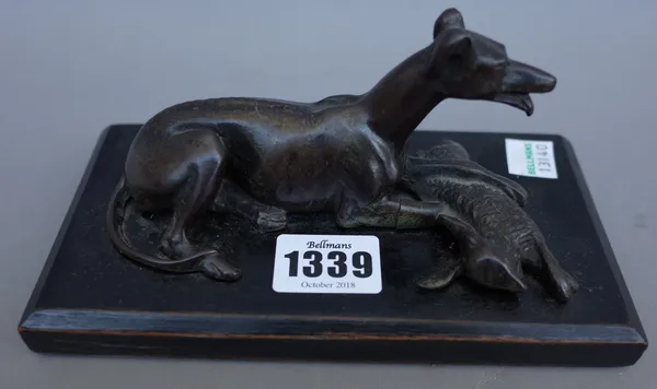 A late 19th century French School bronze figure of a coursing greyhound, recumbent with dead hare, on a black wooden base, unsigned, 17.5cms wide; and
