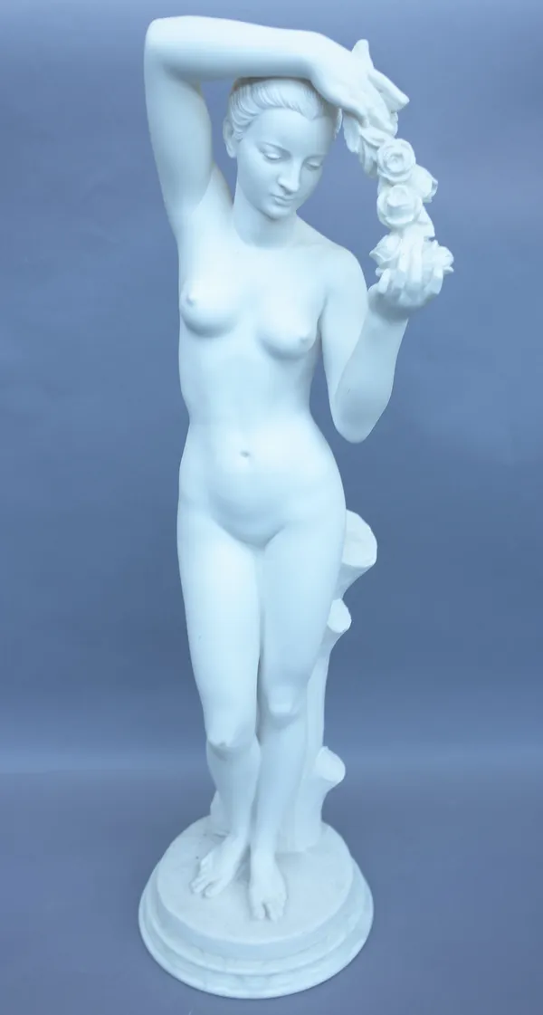 A modern alabaster/composite statue of a nude female holding a garland of flowers on a naturalistic circular base. 80cm high.