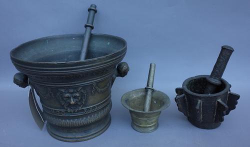 A 16th century Spanish bronze pestle and mortar of large proportions, dated 1530, with twin figural handles (21cm high), one further bronze pestle and