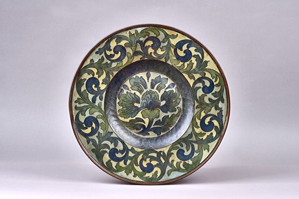 An unusual Arts and Crafts charger, first half, 20th century, foliate enamel inlaid copper in tones of blues and greens, unsigned, 42cm diameter. Illu